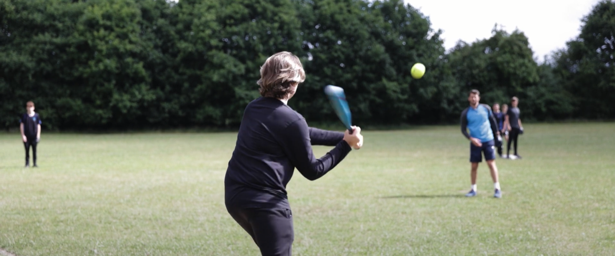 Image shows pupils playing rounders in PE class on one of our school fields.