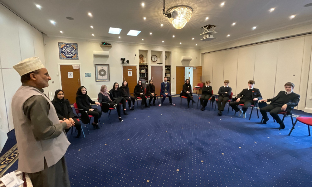 Image shows the year 10 pupils talking to the Imam