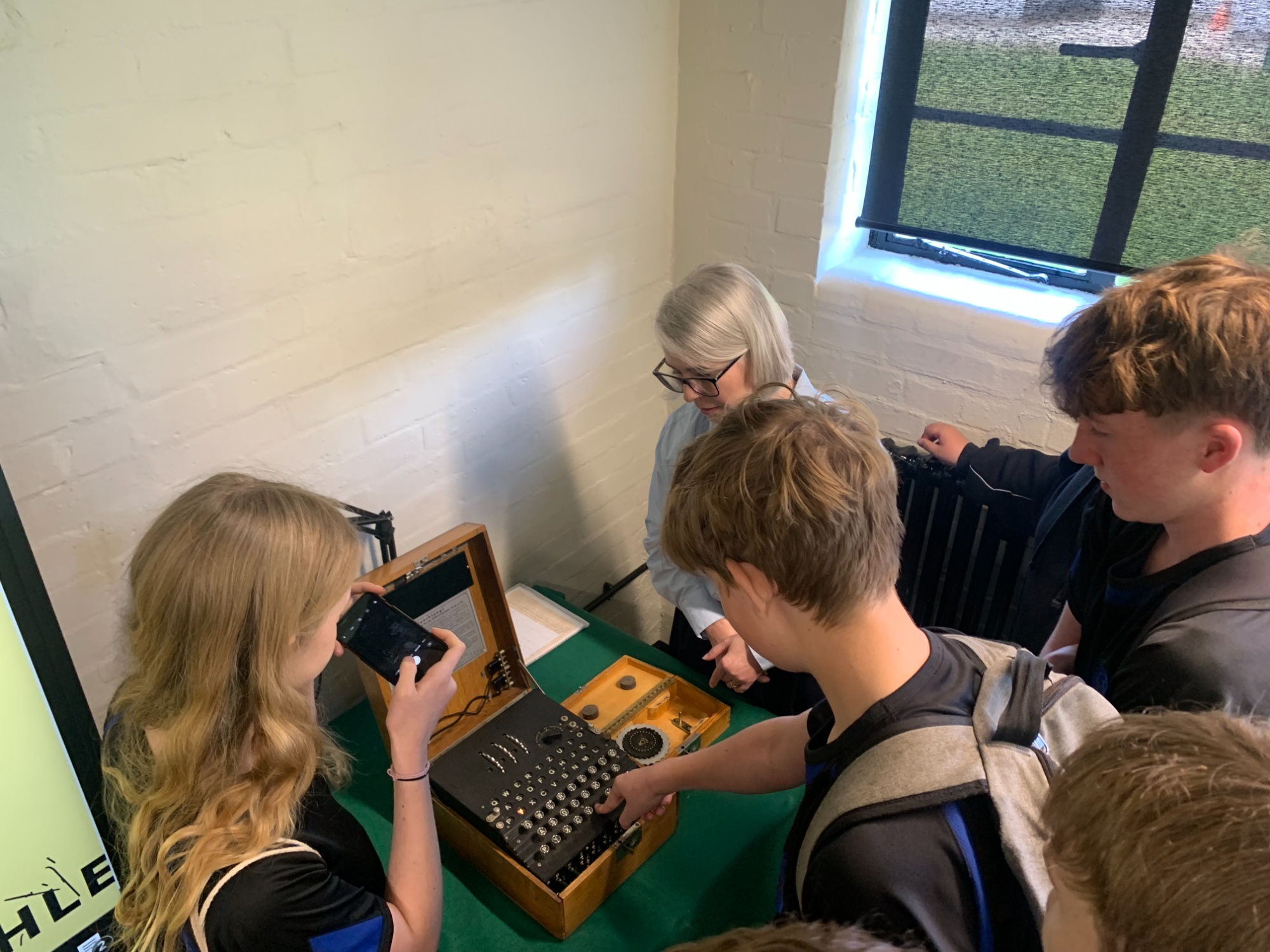 Image shows a group of pupils looking at an Enigma machine