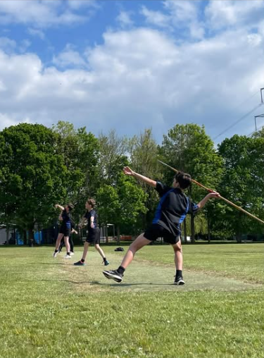 Image shows 3 pupils throwing their javelins, taken from the side