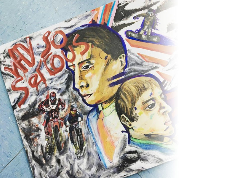 Image shows a pupil's painting with people snowboarding, racing on bikes, with 2 large serious looking faces and the words why so serious