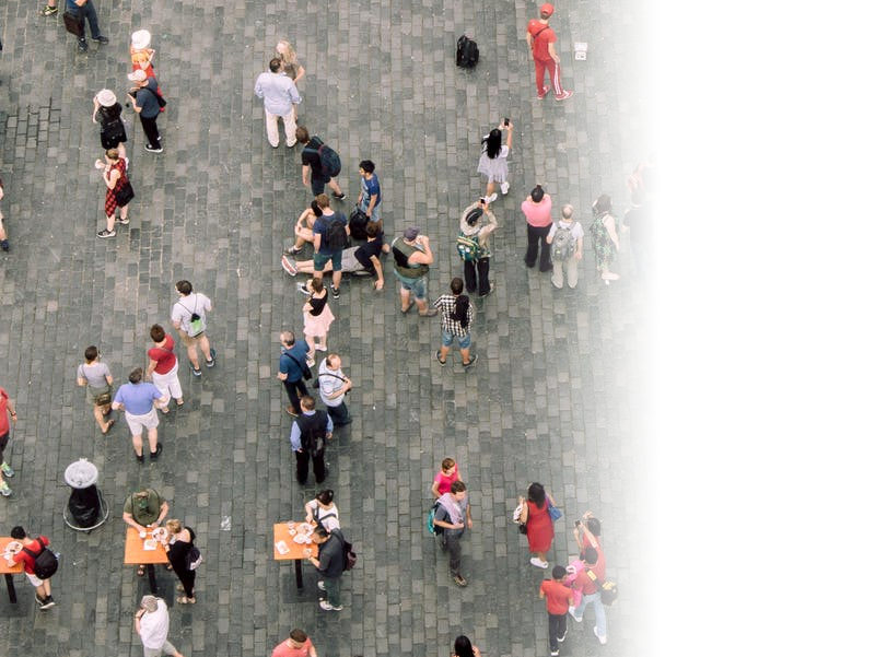 Image is taken from above and shows people standing and walking over a pedestrianised area