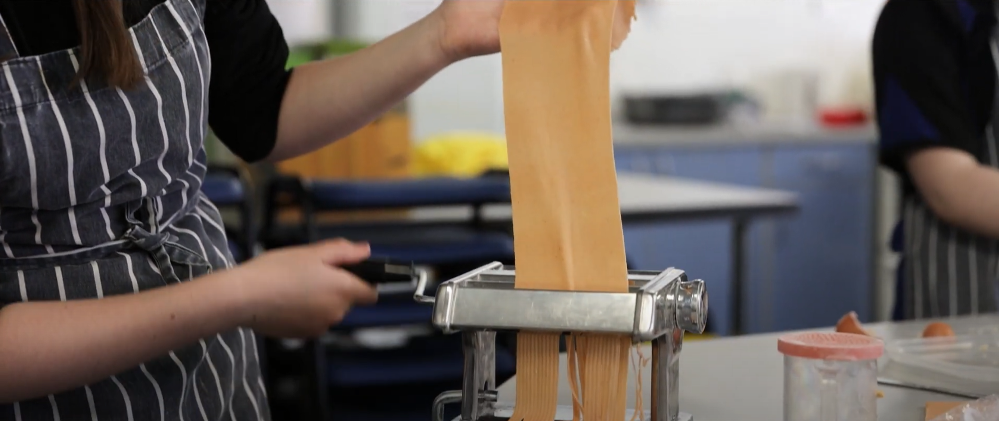 Image shows a pupil making pasta in a Food Technology class.