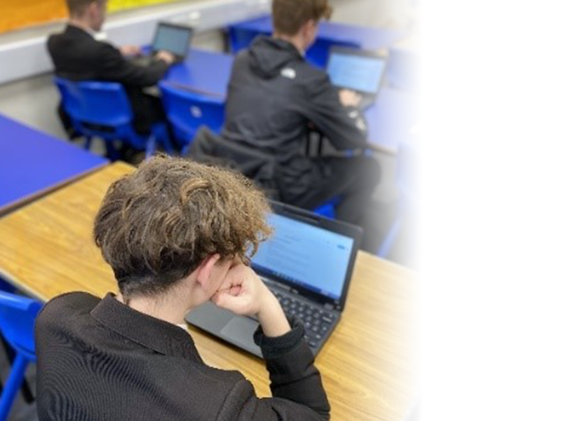 Image shows pupils sitting at desks using Chromebooks to study