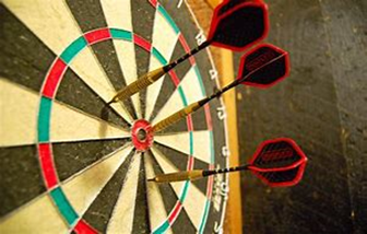 Image shows 3 darts in a dartboard with one in the bullseye