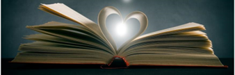 Image shows an open book with the middle pages bent into a heart, and a light is shining through it